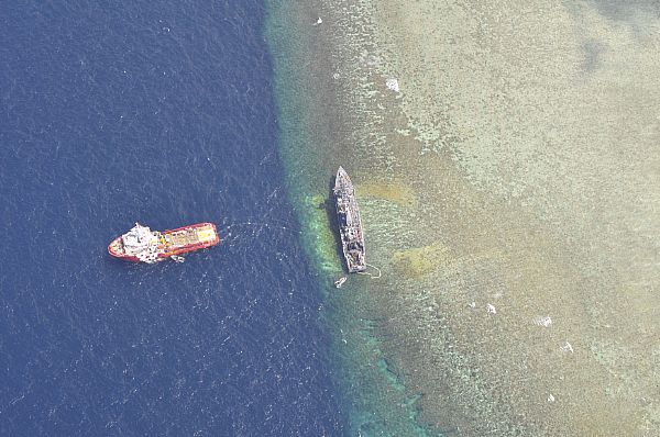 The U.S. Navy-contracted Malaysian tug Vos Apollo seen removing fuel and human wastewater from the mine countermeasure ship USS Guardian, which ran aground on the Tubbataha Reef in the Sulu Sea on Jan. 17. US Navy Photo