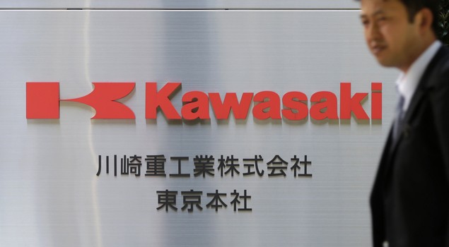 A man walks past a signboard of Kawasaki Heavy Industries, Ltd. at the company's Tokyo Head Office in Tokyo April 22, 2013. Image (c) REUTERS/Toru Hanai