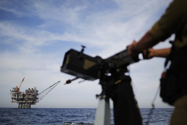 An Israeli gas platform is seen in the back as a sailor in the Israeli navy stands aboard a patrol boat in the Mediterranean sea some 15 miles (24 km) west of the port city of Ashdod February 25, 2013. REUTERS/Amir Cohen