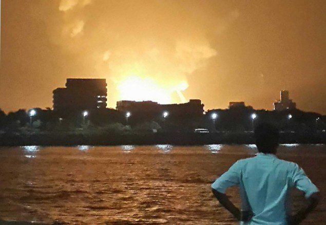 A man watches Indian Navy submarine INS Sindhurakshak on fire in Mumbai late August 13, 2013. Picture taken late August 13, 2013. REUTERS/Vikalp Shah